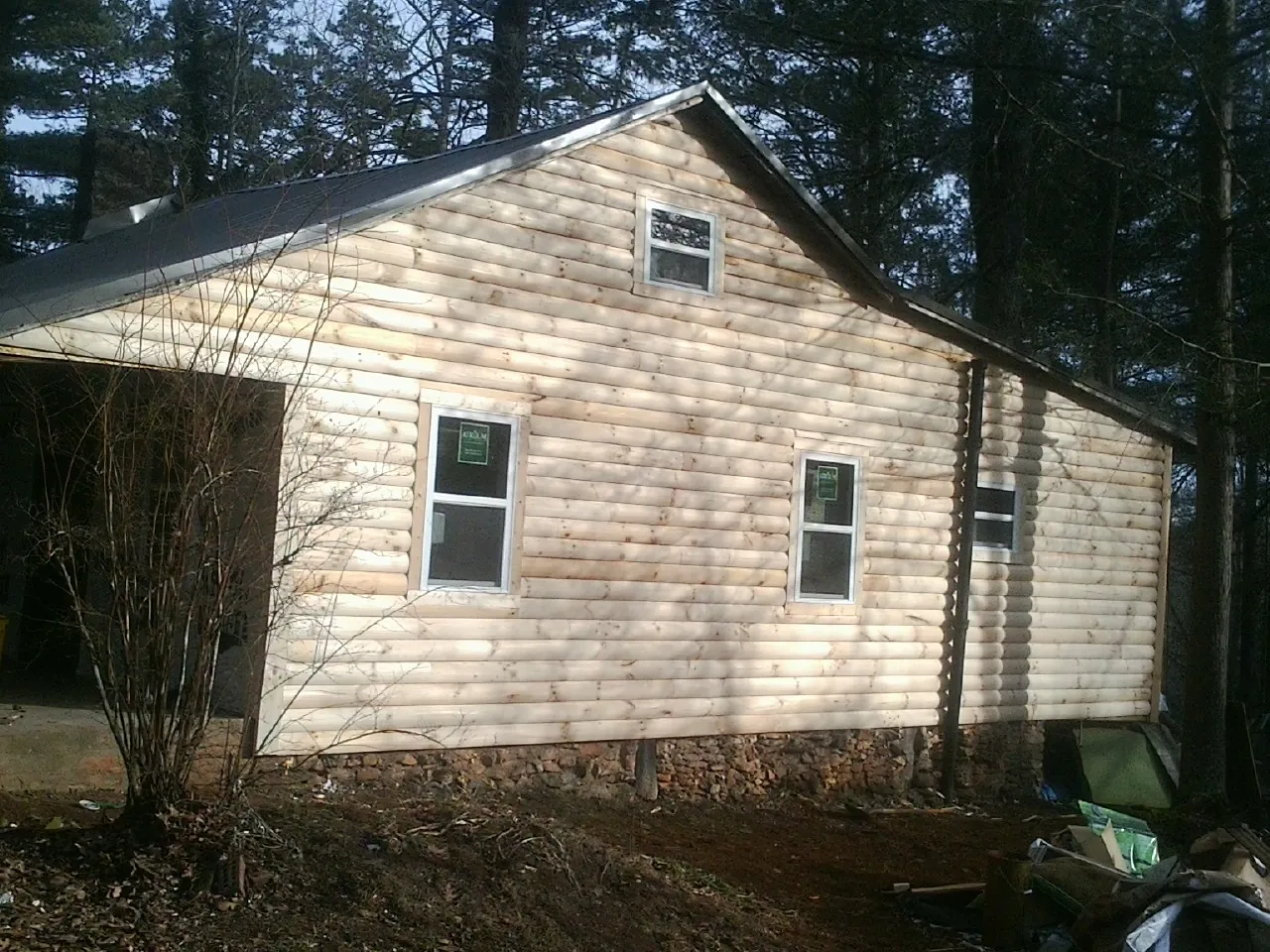 New log siding and dark metal roofing on a gable end in Riverside